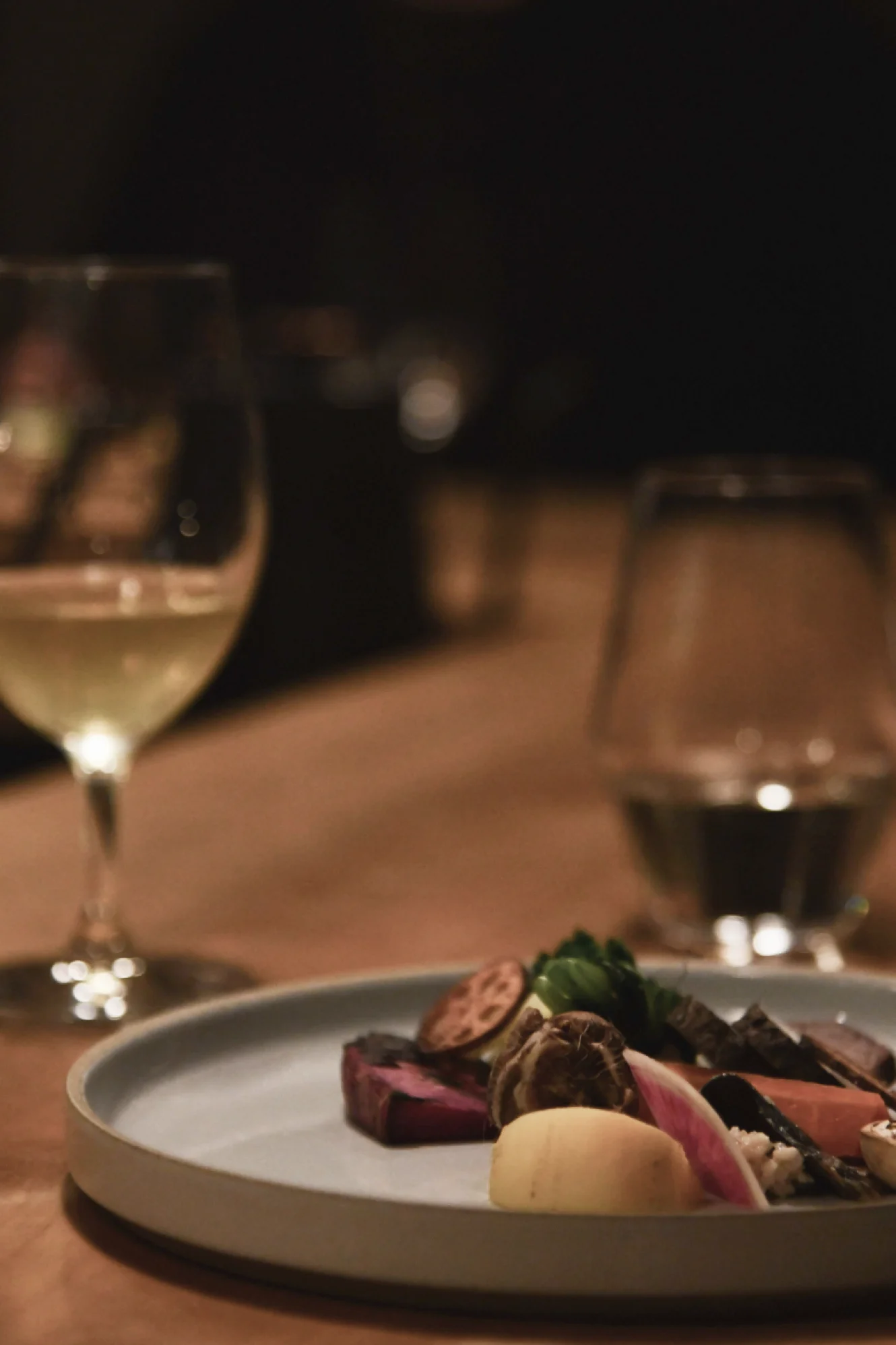 Seasonal tasting plate with wine glasses on table