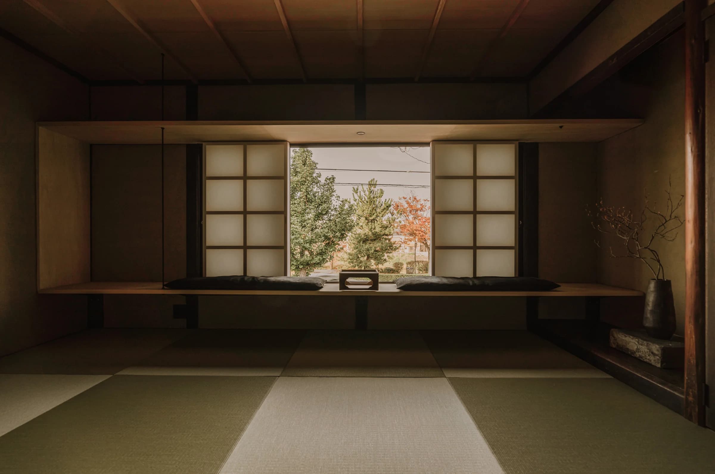Tatami room with open shoji screens framing autumn garden view