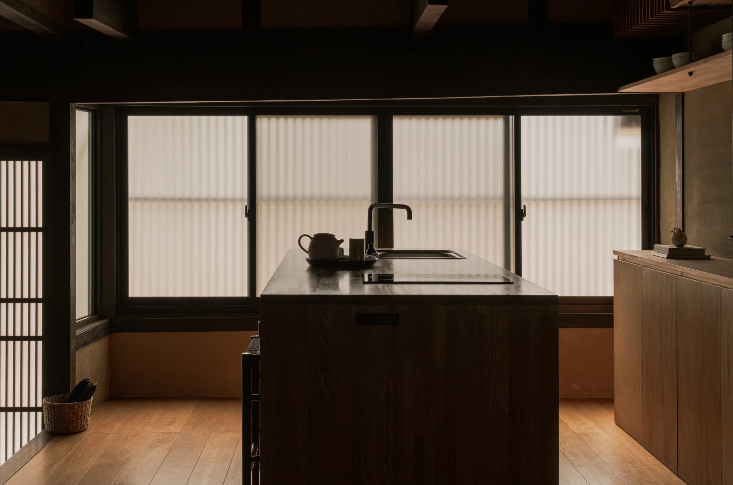 Kitchen island with teapot and cups against frosted glass windows
